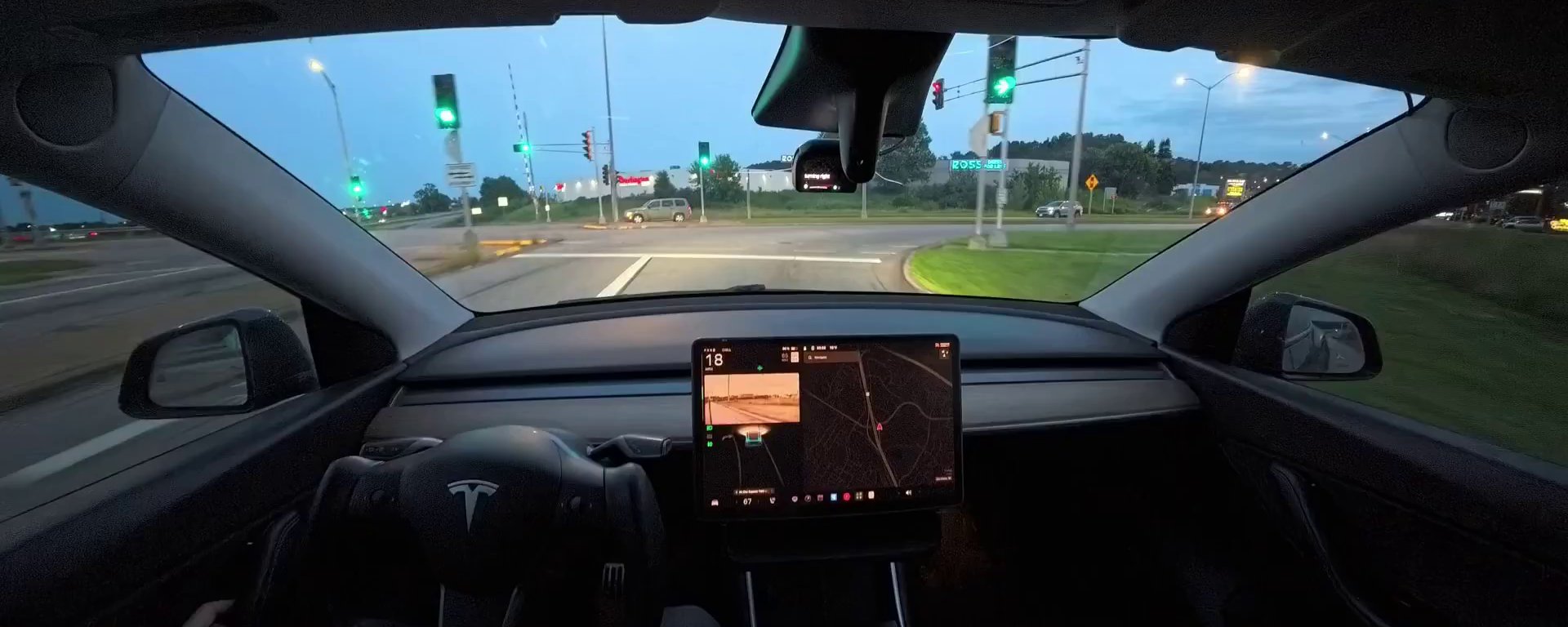 View from the driver's seat of my Model Y at a green light, comma four on the windshield